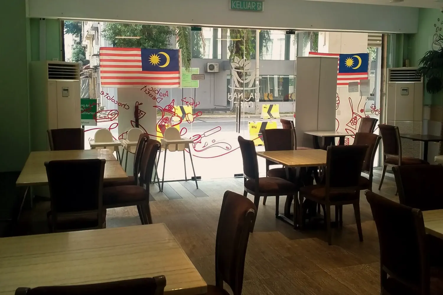 The dining room at Madinah Restaurant & Café, with wooden tables and the street outside